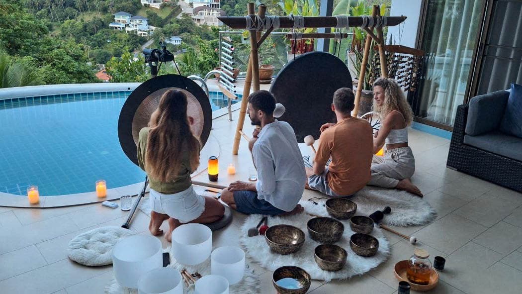 Participants learning to play gongs and bowls during a sound workshop.